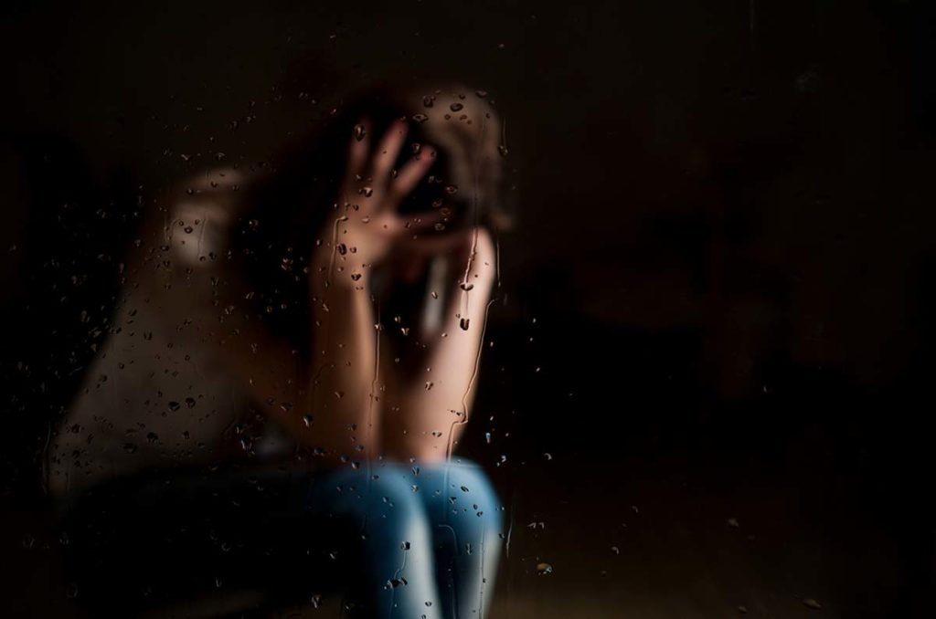Person sitting with hands in their hair, wondering, "How long does it take to detox from heroin?"